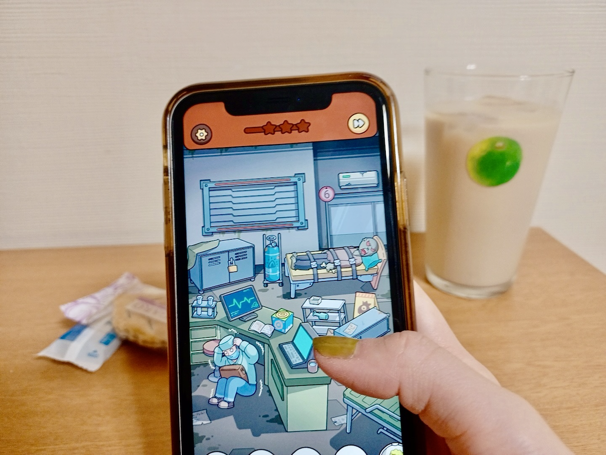 写真:カフェラテとお菓子を前にゲームをする手元