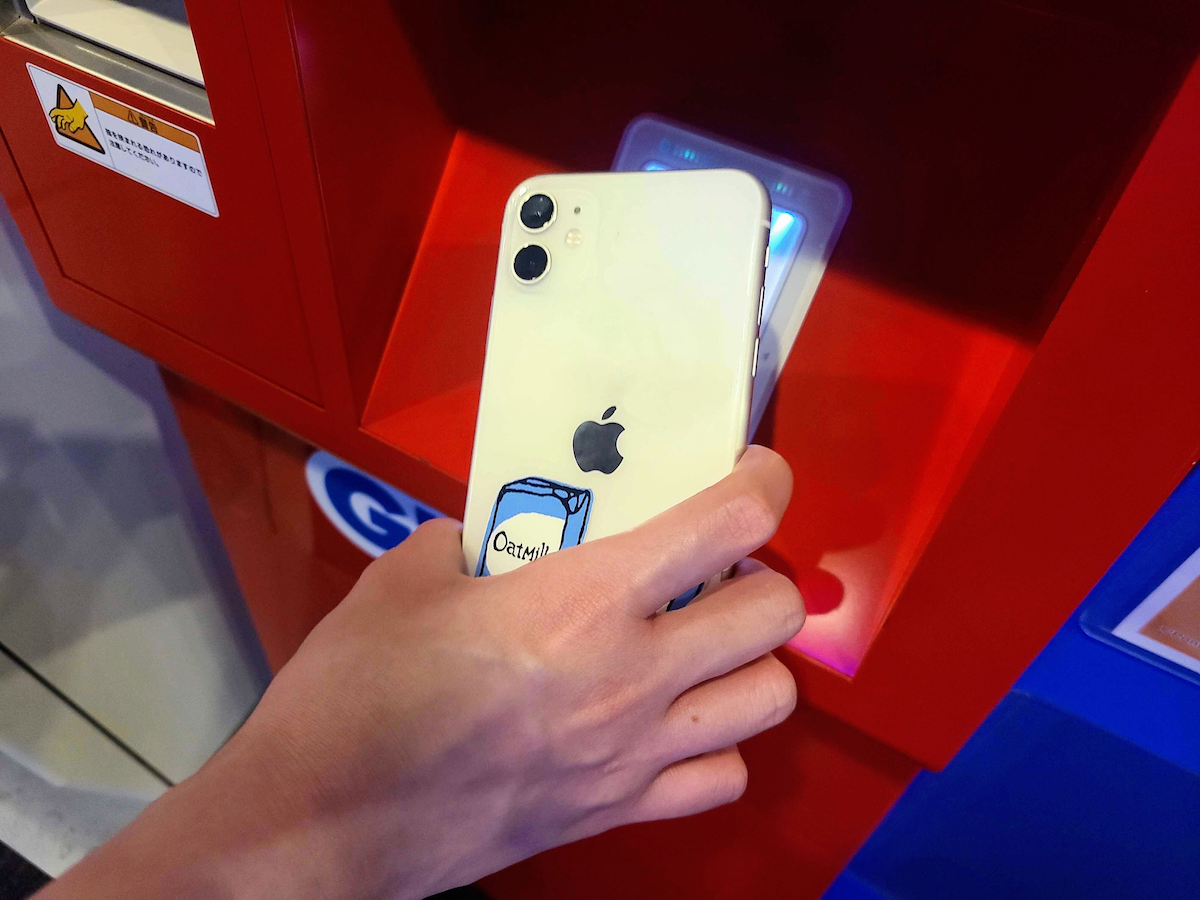 写真:端末にスマホをかざす手