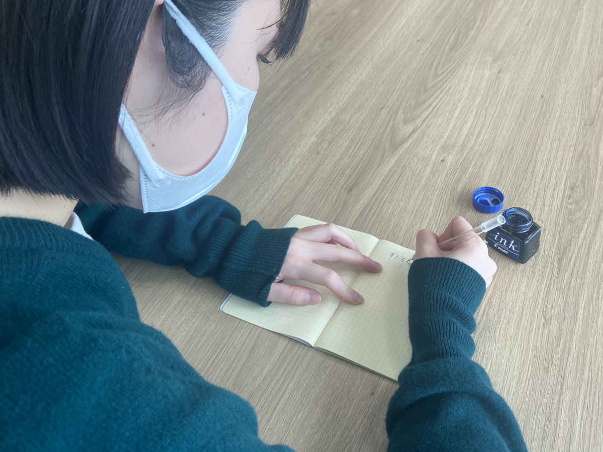 写真:購入品のノートと万年筆、インクをつかって文字を書き始めるすだち